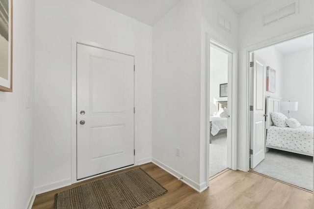 foyer with visible vents, baseboards, and wood finished floors