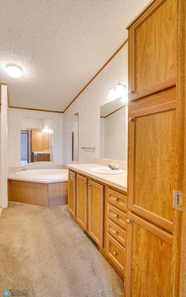 full bathroom featuring a bath, a textured ceiling, crown molding, and vanity