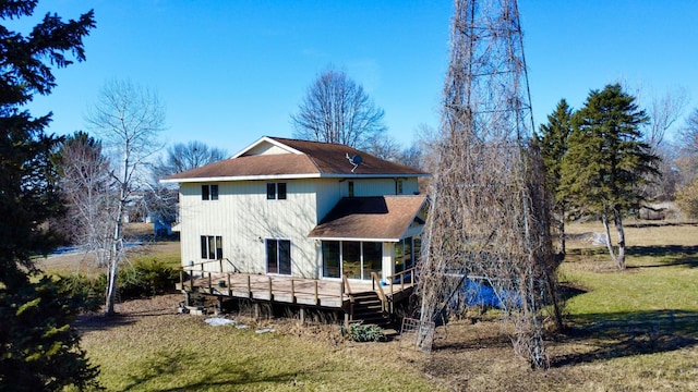 back of property featuring a lawn and a wooden deck