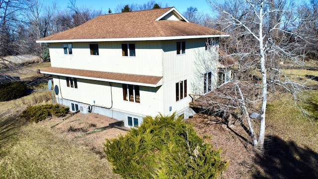 view of property exterior with a shingled roof