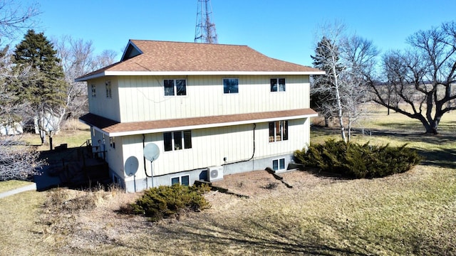 rear view of house with ac unit and roof with shingles