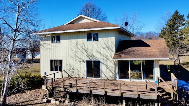 rear view of house featuring a shingled roof and a deck