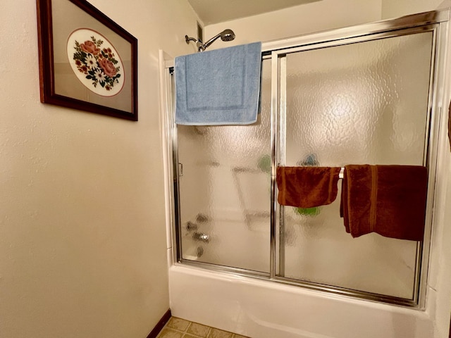 full bathroom with baseboards and bath / shower combo with glass door