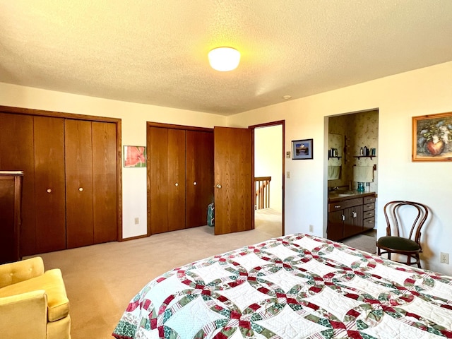 carpeted bedroom with multiple closets and a textured ceiling