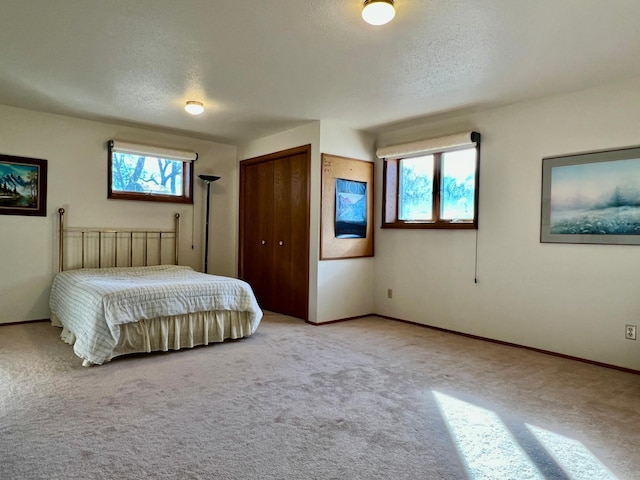 unfurnished bedroom with light carpet, baseboards, and a textured ceiling