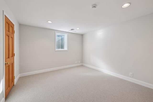 spare room with recessed lighting, light colored carpet, and baseboards