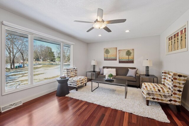 living room featuring visible vents, a ceiling fan, dark wood finished floors, recessed lighting, and baseboards