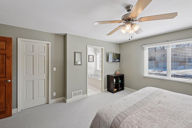 carpeted bedroom featuring visible vents, a ceiling fan, ensuite bathroom, and baseboards