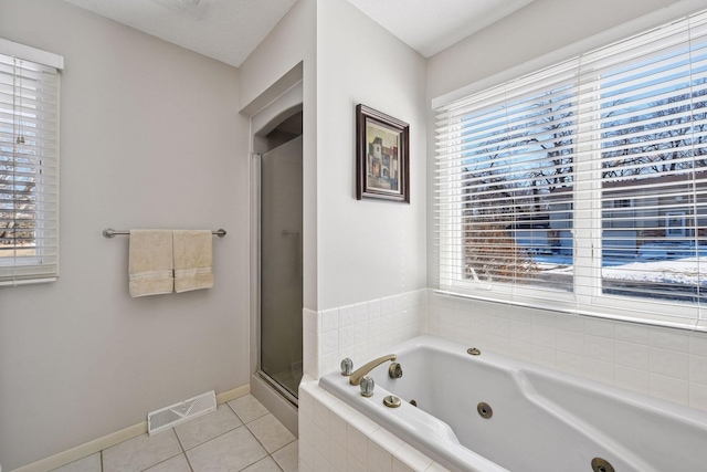 bathroom with tile patterned floors, visible vents, a healthy amount of sunlight, and a whirlpool tub