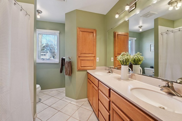 full bathroom with a sink, baseboards, toilet, and tile patterned flooring