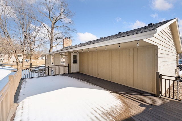 snow covered property with a chimney