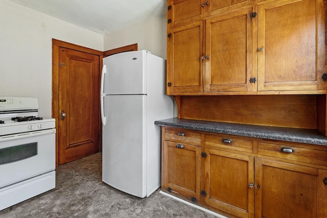 kitchen with white appliances, dark countertops, and brown cabinets