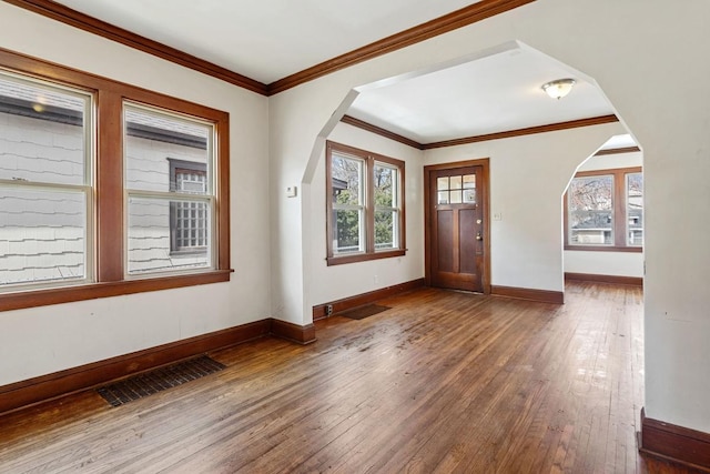 foyer featuring arched walkways, visible vents, and wood-type flooring