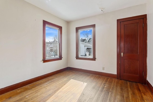 spare room with hardwood / wood-style floors and baseboards