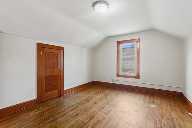 bonus room featuring lofted ceiling, baseboards, and wood-type flooring