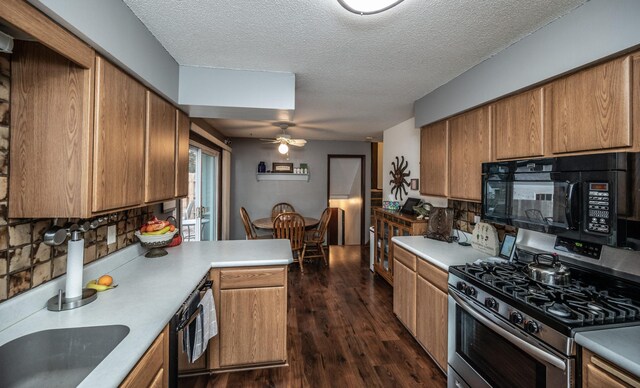 kitchen featuring decorative backsplash, black microwave, dark wood-type flooring, and stainless steel range with gas stovetop