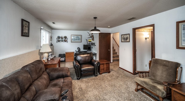 living room with carpet floors, stairs, visible vents, and a textured ceiling