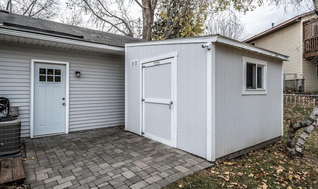 view of shed with cooling unit and fence