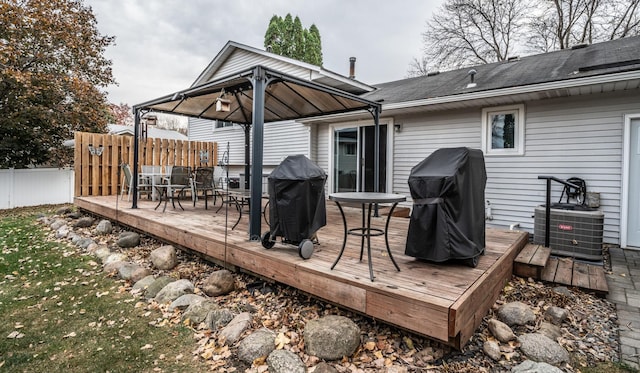 wooden terrace featuring a grill, fence, central AC, and a gazebo