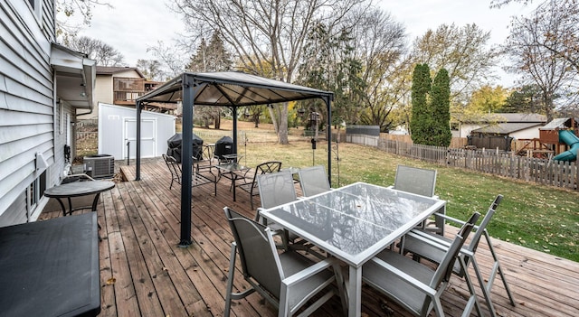 deck featuring a yard, a storage unit, a gazebo, outdoor dining space, and an outdoor structure