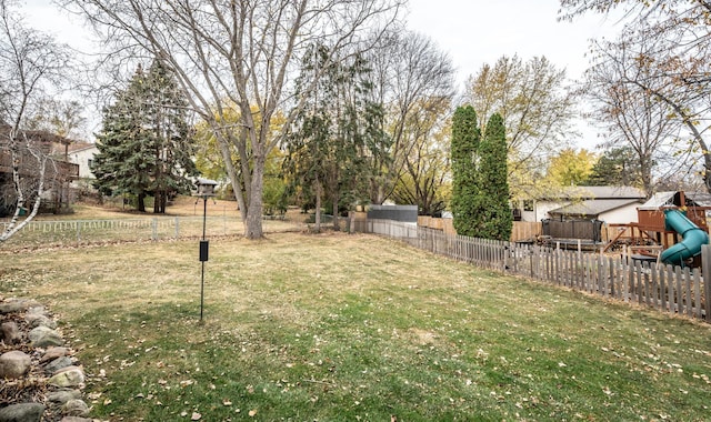 view of yard with a playground and a fenced backyard