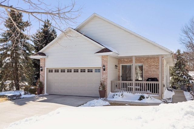 view of front of property with brick siding, an attached garage, a porch, and driveway