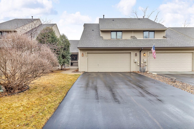 view of front facade with a garage, a shingled roof, aphalt driveway, and a front yard