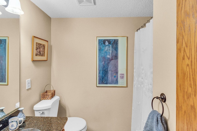 full bath with toilet, visible vents, a textured ceiling, and vanity