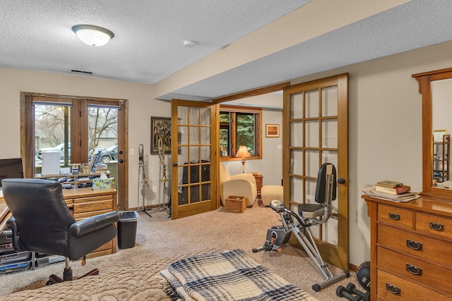 exercise room with a textured ceiling, visible vents, baseboards, french doors, and carpet