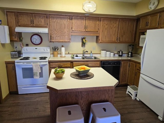 kitchen featuring dark wood finished floors, light countertops, a sink, white appliances, and under cabinet range hood