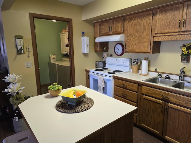 kitchen featuring light countertops, electric range, a sink, separate washer and dryer, and under cabinet range hood