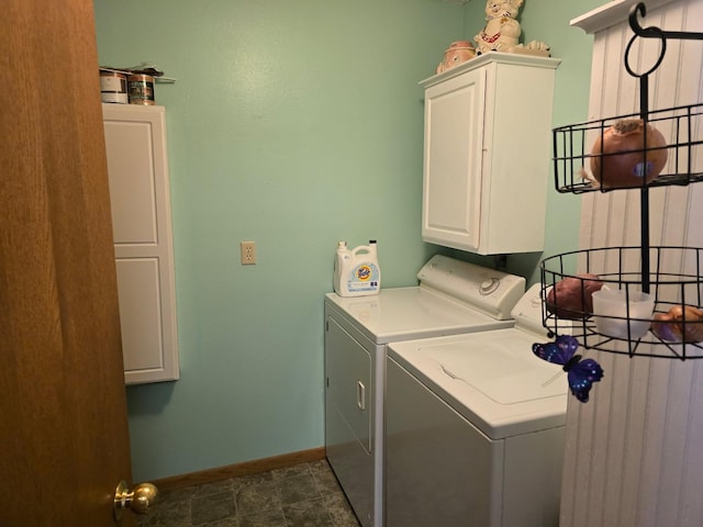 clothes washing area with cabinet space, washer and clothes dryer, and baseboards