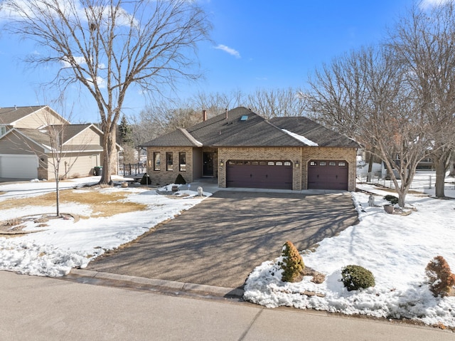 view of front of property featuring brick siding, an attached garage, and driveway