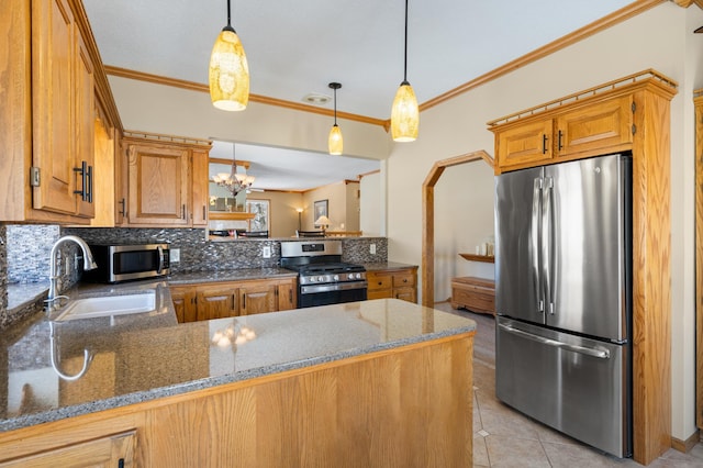 kitchen with a sink, backsplash, appliances with stainless steel finishes, a peninsula, and light tile patterned flooring