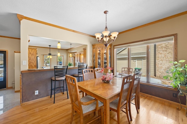 dining space featuring plenty of natural light, baseboards, light wood-type flooring, and an inviting chandelier