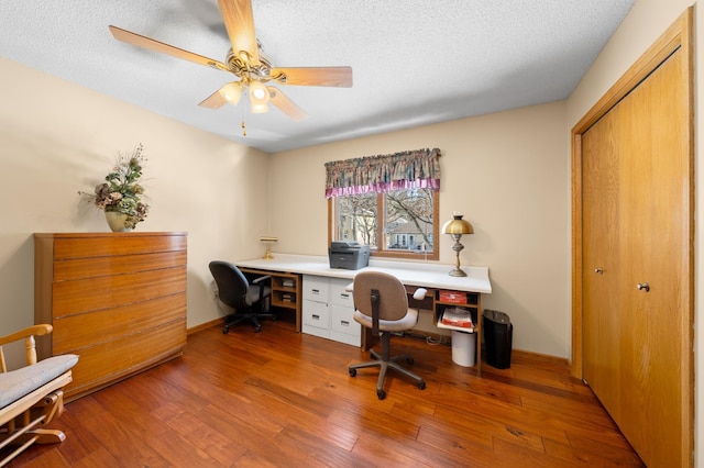 home office with a textured ceiling, ceiling fan, and hardwood / wood-style flooring