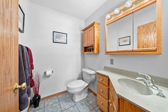 half bath with tile patterned floors, toilet, a textured ceiling, baseboards, and vanity