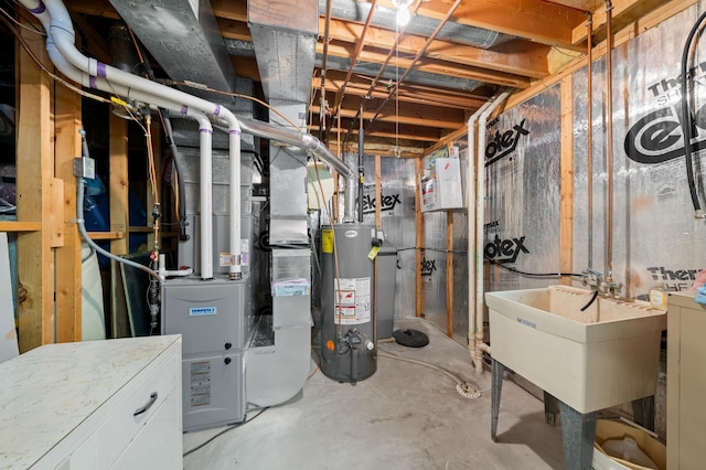 utilities with heating unit, separate washer and dryer, water heater, and a sink