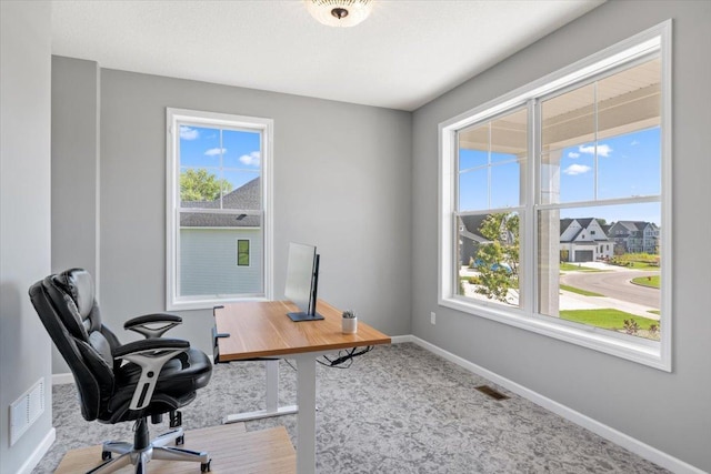 carpeted office with visible vents and baseboards