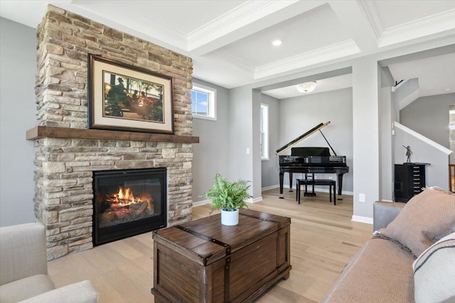 living area featuring beam ceiling, a fireplace, crown molding, light wood-style floors, and baseboards