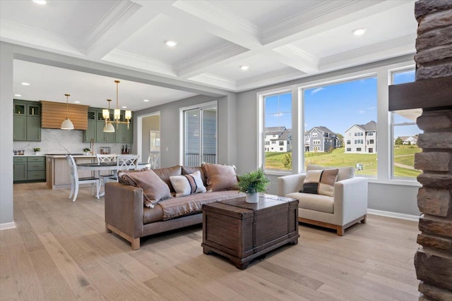 living room with a chandelier, beam ceiling, and light wood finished floors