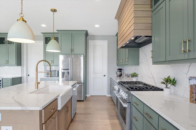 kitchen featuring stainless steel appliances, light wood-style floors, tasteful backsplash, decorative light fixtures, and custom range hood