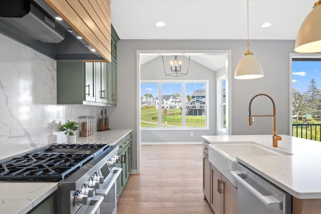 kitchen with light wood finished floors, tasteful backsplash, stainless steel appliances, ventilation hood, and a sink