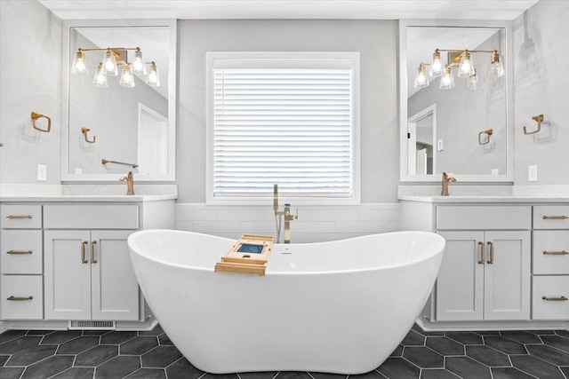 full bathroom featuring visible vents, a freestanding tub, tile patterned flooring, and tile walls