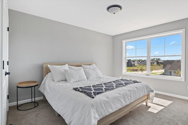 bedroom featuring carpet and baseboards