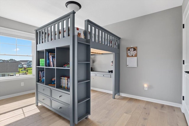 bedroom featuring light wood-style flooring and baseboards