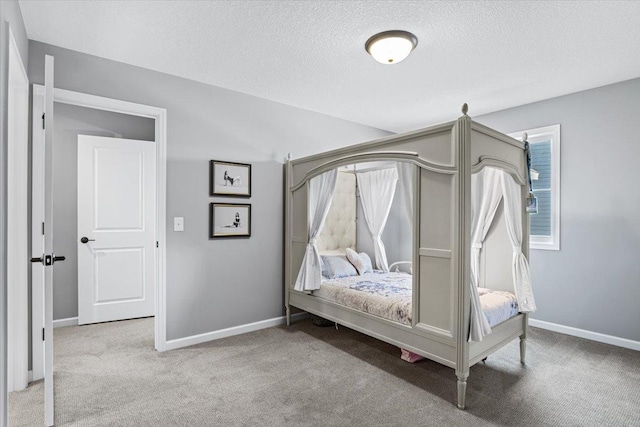 carpeted bedroom featuring baseboards and a textured ceiling