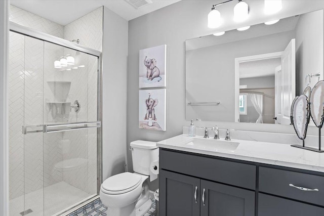 bathroom with a stall shower, visible vents, vanity, and toilet