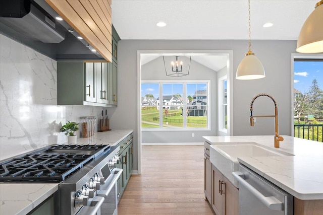 16700 47th Ave N, Plymouth, MN 55446 - kitchen with stainless steel appliances, wall chimney range hood, light wood finished floors, a sink, and a chandelier