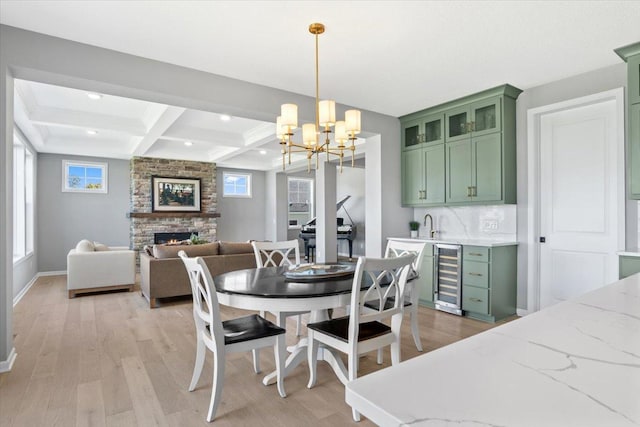 16700 47th Ave N, Plymouth, MN 55446 - dining space featuring wine cooler, wet bar, light wood-style flooring, a fireplace, and coffered ceiling
